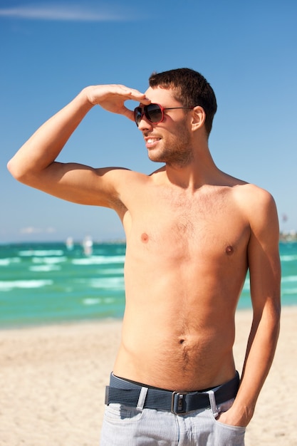 image lumineuse d'un homme souriant heureux sur la plage.