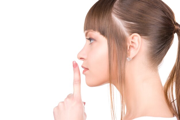 Photo image lumineuse de la jeune femme avec le doigt sur les lèvres