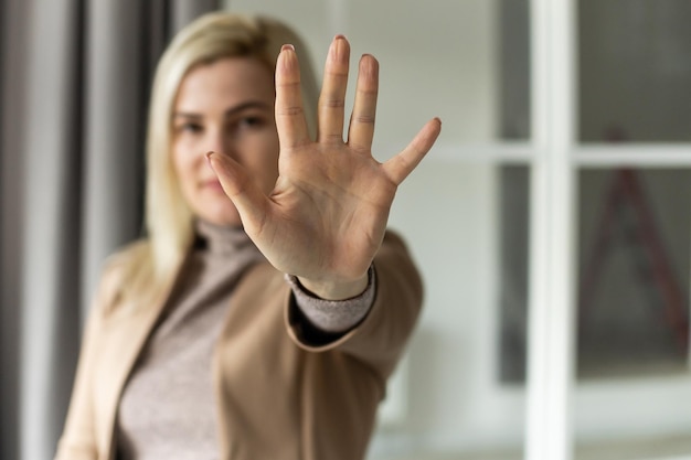 Image lumineuse de la jeune femme faisant le geste d'arrêt