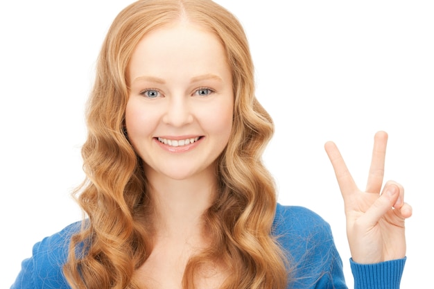 image lumineuse d'une jolie adolescente montrant le signe de la victoire