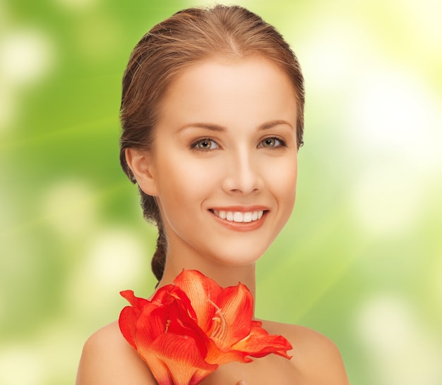 Photo image lumineuse d'une jolie femme avec une fleur de lys rouge