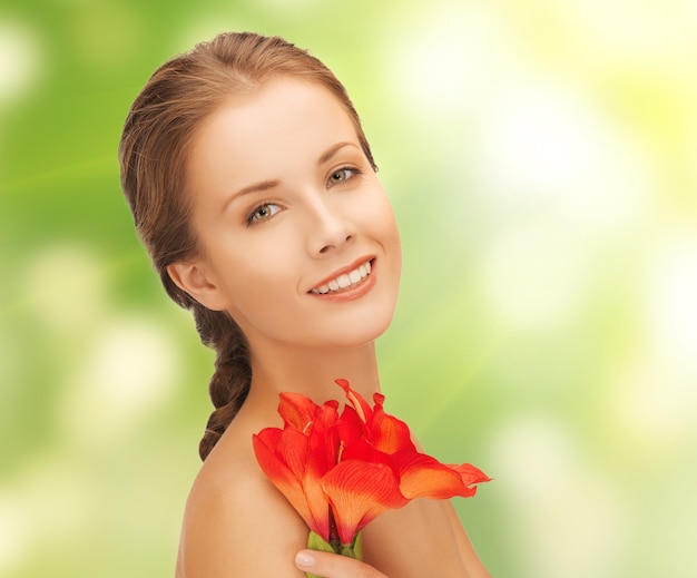 image lumineuse d'une jolie femme avec une fleur de lys rouge