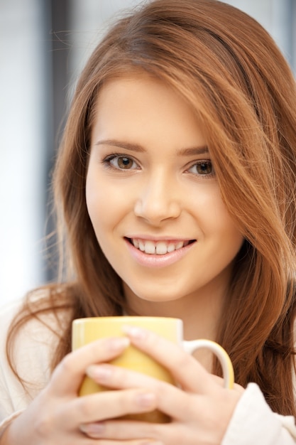 image lumineuse d'une jolie femme avec une tasse