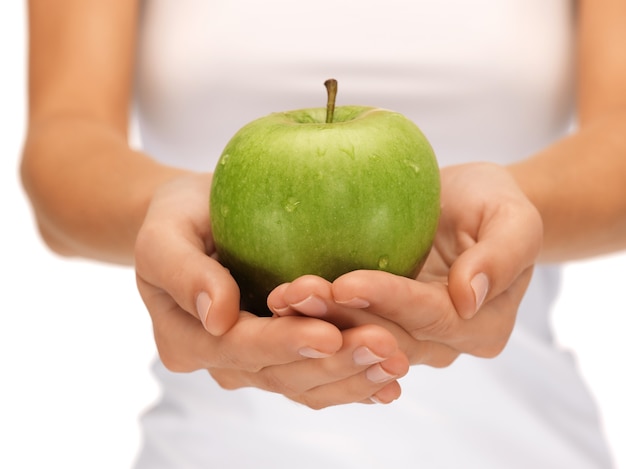 image lumineuse de mains féminines avec pomme verte