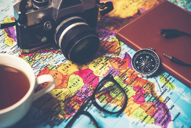 Photo image de lunettes avec boussole et caméra sur la carte du monde