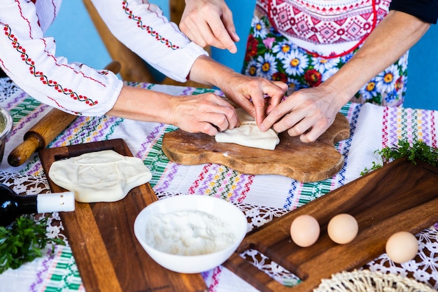 image avec les mains d'une dame cuisinant des tartes frites roumaines traditionnelles avec du fromage