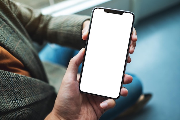 Image maquette d'une femme tenant et montrant un téléphone portable blanc avec un écran de bureau noir vierge à quelqu'un