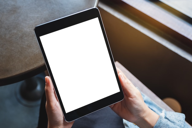 Image de maquette d'une femme tenant une tablette noire avec un écran blanc blanc