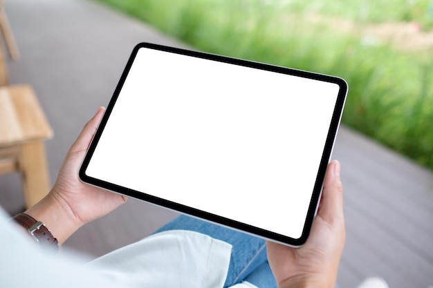 Image maquette d'une femme tenant une tablette numérique avec un écran de bureau blanc vierge à l'extérieur