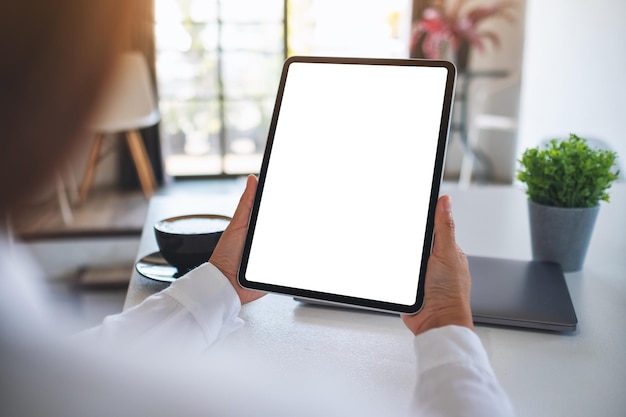 Image maquette d'une femme tenant une tablette numérique avec un écran de bureau blanc vierge