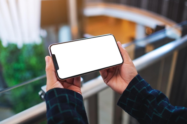 Image de maquette d'une femme tenant un téléphone portable avec un écran blanc vierge à l'intérieur