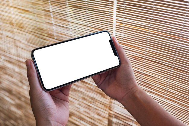 Image maquette d'une femme tenant un téléphone portable avec un écran de bureau blanc vierge