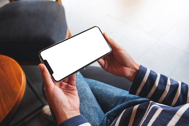 Image maquette d'une femme tenant un téléphone portable avec un écran de bureau blanc vierge