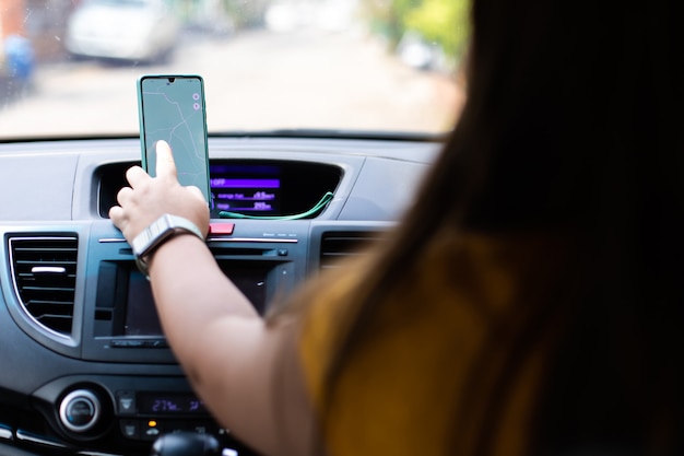 image maquette d'une femme utilisant un smartphone avec écran vide. belle grosse femme conduisant une voiture