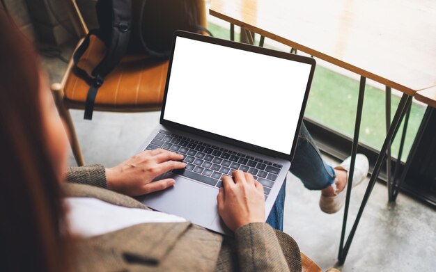 Image maquette d'une femme utilisant et tapant sur un ordinateur portable avec un écran de bureau blanc vierge