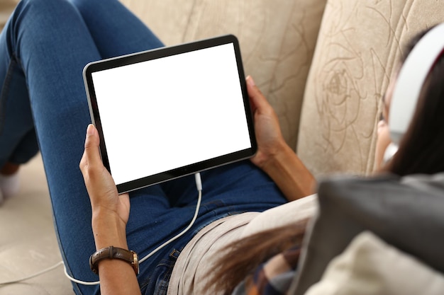 Image maquette d'une tablette numérique avec écran noir dans les mains d'une femme au casque