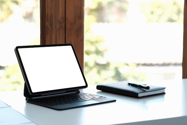 image de maquette de tablette numérique noire avec écran blanc de bureau vierge sur l'espace de travail au bureau à domicile.