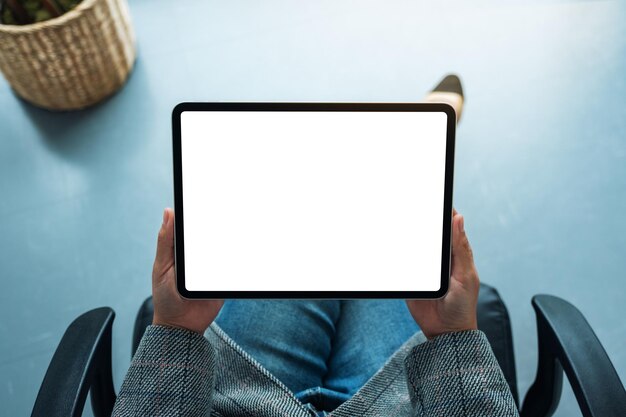 Image maquette vue de dessus d'une femme d'affaires tenant une tablette numérique avec un écran de bureau blanc vierge