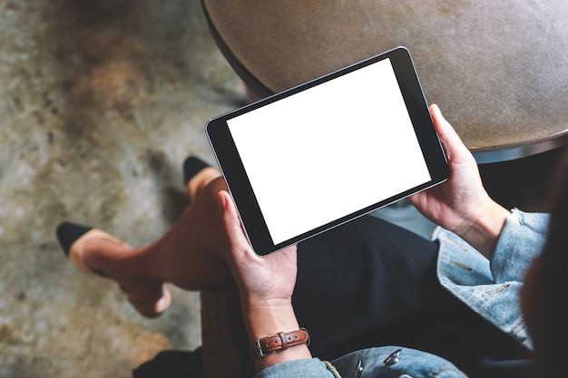 Image de maquette vue de dessus d'une femme tenant une tablette noire avec un écran blanc blanc