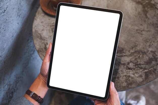 Image maquette vue de dessus d'une femme tenant une tablette numérique avec un écran de bureau blanc vierge