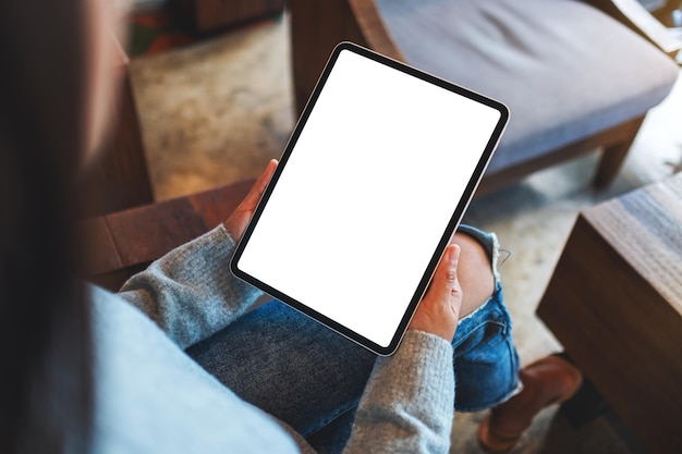 Image maquette vue de dessus d'une femme tenant une tablette numérique avec un écran de bureau blanc vierge