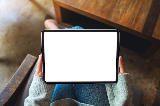 Image maquette vue de dessus d'une femme tenant une tablette numérique avec un écran de bureau blanc vierge