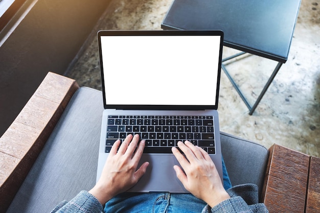 Image de maquette vue de dessus d'une femme utilisant et tapant sur un ordinateur portable avec un écran de bureau blanc vierge