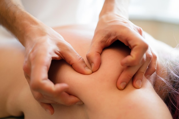 Image d'un masseur de mains faisant un massage à une jeune fille.