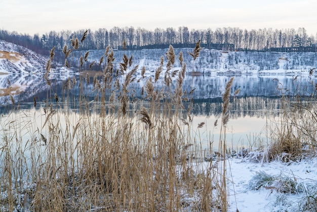 Une image miroir de la rive avec une couverture de neige sur le réservoir