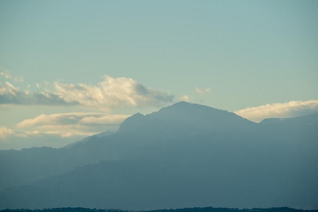 Photo image d'une montagne avec des nuages blancs denses au-dessus