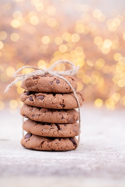 L'image montre une pile de cookies aux pépites de chocolat américain sur une planche en bois rustique.