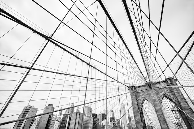 Image en noir et blanc du pont de Brooklyn à New York. Horizon de Manhattan en arrière-plan