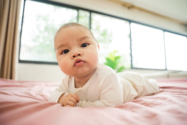 Image d'un nouveau-né allongé sur un lit rose