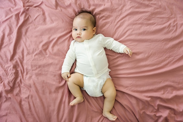 Image d'un nouveau-né allongé sur un lit rose