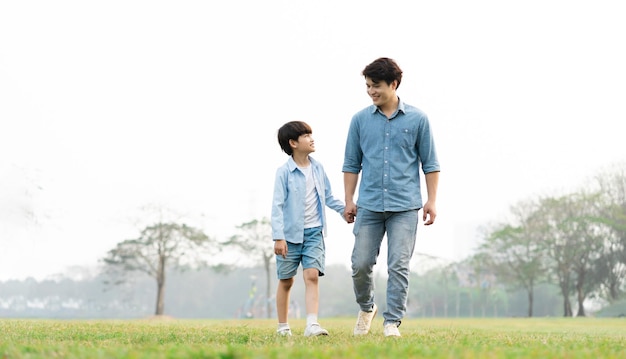 Image d'un père et d'un fils asiatiques s'amusant dans le parc