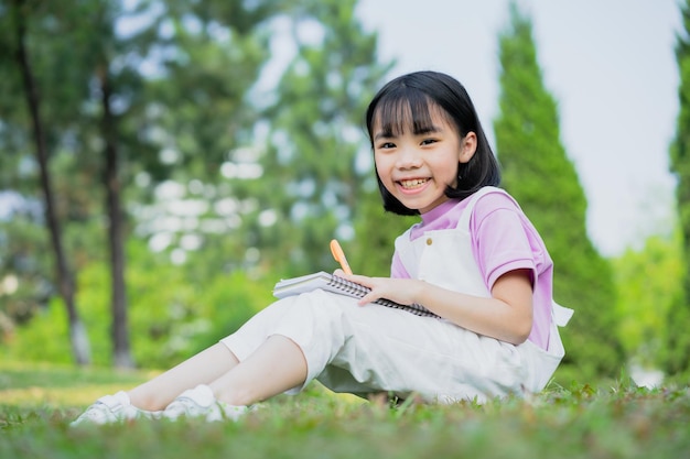 Image d'une petite fille asiatique étudiant au parc