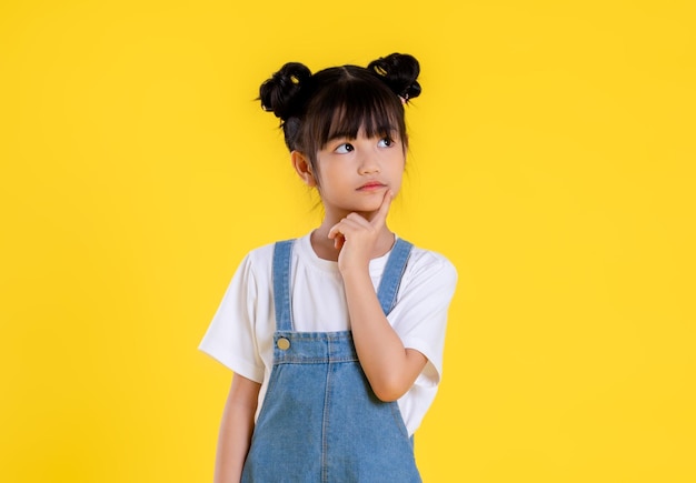 Image de petite fille asiatique posant sur un fond jaune