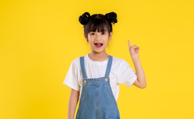 Image de petite fille asiatique posant sur un fond jaune