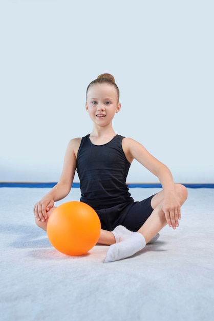 Image d'une petite fille avec une balle dans le gymnase Concept de gymnastique Médias mixtes