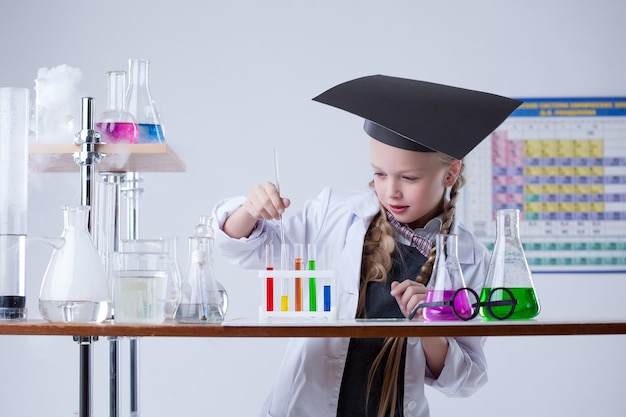 Image d'une petite fille intelligente mélangeant des réactifs en laboratoire