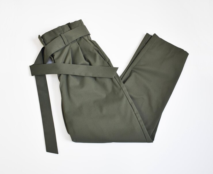 Photo une image plate d'un pantalon vert kaki plié avec une ceinture sur un fond blanc