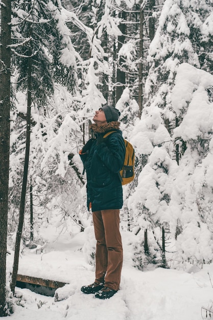 Image pleine longueur de l'homme dans la forêt d'hiver