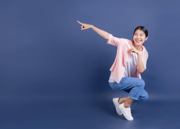 Image pleine longueur de jeune femme asiatique debout sur fond