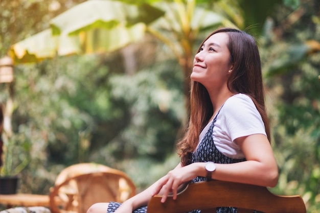 Image portrait d'une belle femme asiatique assise à l'extérieur avec un fond de nature