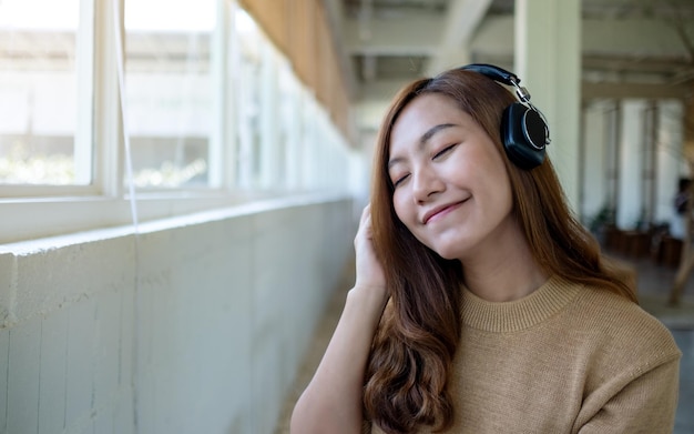 Image de portrait d'une belle jeune femme asiatique aime écouter de la musique avec un casque