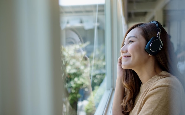 Image de portrait d'une belle jeune femme asiatique aime écouter de la musique avec un casque