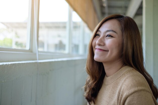 Image de portrait d'une belle jeune femme asiatique assise dans un café avec un sentiment de bonheur