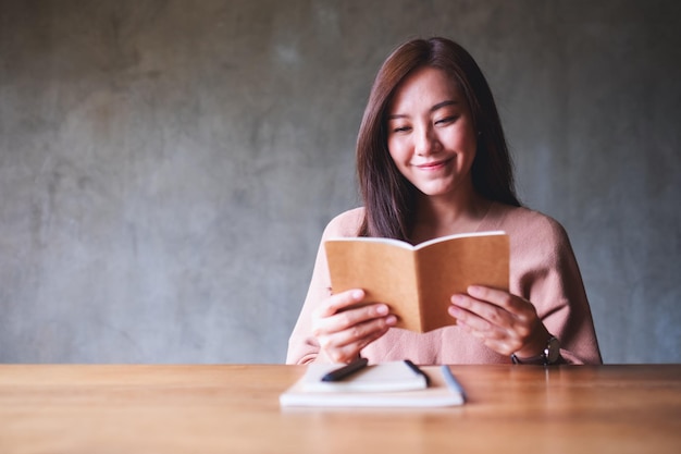 Image de portrait d'une belle jeune femme asiatique lisant un livre