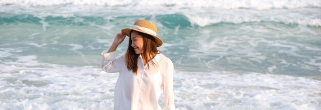 Image de portrait d'une belle jeune femme asiatique se promenant sur la plage au bord de la mer