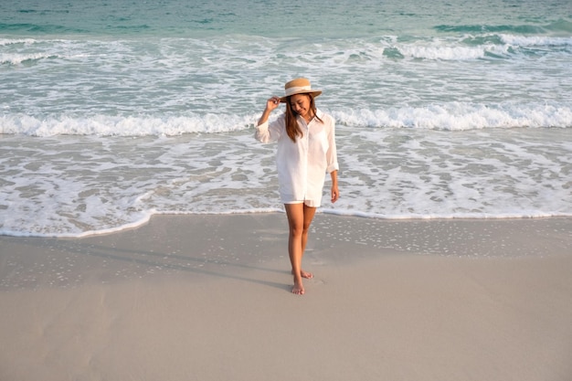 Image de portrait d'une belle jeune femme asiatique se promenant sur la plage au bord de la mer